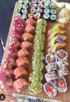 an assortment of sushi is displayed on a cutting board with the words sushi written below it