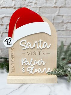 a wooden sign with santa's hat on it