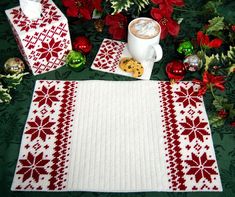 a white and red place mat next to a cup of coffee