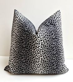 a black and white pillow sitting on top of a table