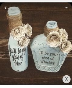 two bottles with roses and twine on them, one has a message in it