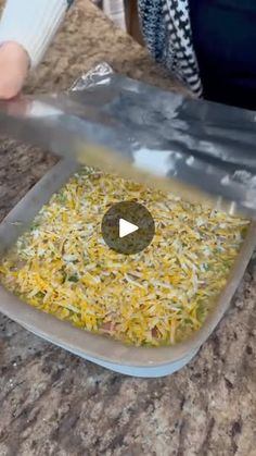 someone is cutting up some food on a counter top with a large plastic bag over it