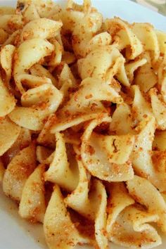 a white plate topped with pasta covered in seasoning