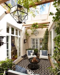 an outdoor living area with white furniture and plants