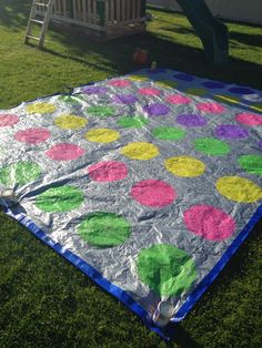 an image of a blanket on the ground with polka dots in green, pink and yellow