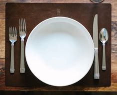 a place setting with silverware on a wooden table