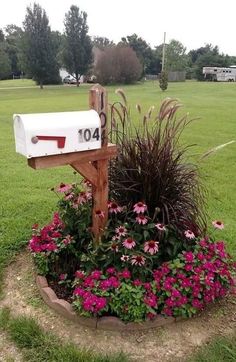 a mailbox sitting in the middle of a flower bed