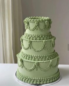 a three tiered green cake sitting on top of a table