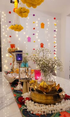 a table topped with lots of vases filled with flowers next to candles and lights