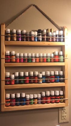 a wooden shelf filled with lots of different types of paint on top of a wall