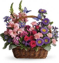 a basket filled with lots of purple and pink flowers