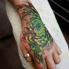 a person with a flower tattoo on their hand