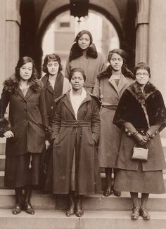 an old black and white photo of women standing on steps