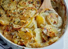 a casserole dish with potatoes and herbs in it, ready to be eaten