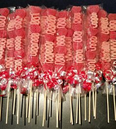 many lollipops are wrapped in cellophane and tied with red ribbon