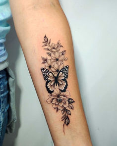 a woman's arm with a butterfly and flowers tattoo on the left inner arm