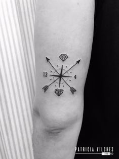 a black and white photo of an arrow tattoo on the left arm, with diamonds in it