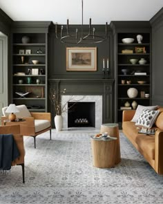 a living room filled with furniture and a fire place under a chandelier in front of a fireplace