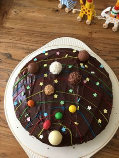 a cake with chocolate icing and various candies on it sitting on a plate