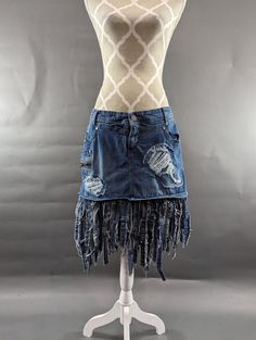 "Upcycled denim skort with frayed fringe hem and distressed patches. Waist measures 35\", hips 38\" and length is approximately 21\". Super fun!" Dark Wash Distressed Cutoff Denim Skirt, Distressed Dark Wash Cutoff Denim Skirt, Bohemian Cutoff Bottoms With Frayed Hem, Fringe Cutoff Denim Jeans, Cutoff Fringe Denim Jeans, Denim Jeans With Fringe Cutoff, Cutoff Denim Jeans With Fringe, Denim Blue Cotton Jeans With Fringe, Fringe Denim Cutoff Jean Shorts