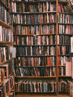 a bookshelf filled with lots of books in a room next to a wooden floor