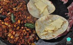 two burritos sitting on top of a pan filled with food