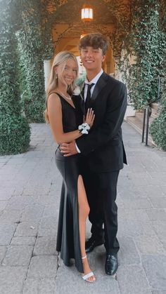 a man and woman in formal wear posing for the camera