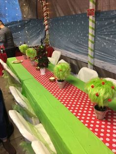 the table is set up with red and white polka dot tablescloths, green centerpieces, and potted plants