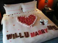 a bed decorated with red and white confetti in the shape of a heart