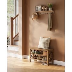 a wooden bench sitting in front of a window next to a wall mounted coat rack