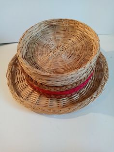 three wicker baskets are stacked on top of each other, one with a red ribbon