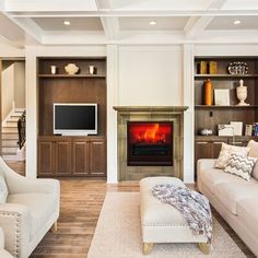 a living room filled with furniture and a flat screen tv mounted on a wall above a fire place