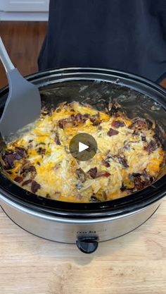 the crock pot is full of food and has a spoon sticking out of it