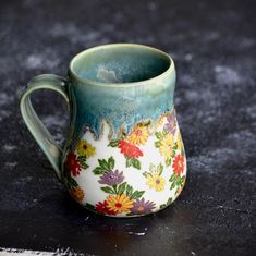 a ceramic mug with flowers painted on it