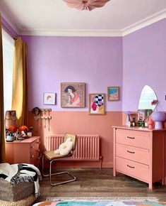 a bedroom with pink and purple walls, furniture and pictures on the wall in it