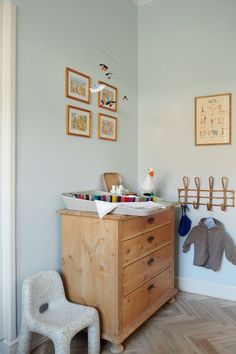 a baby's crib in the corner of a room with pictures on the wall