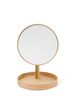 a round mirror sitting on top of a wooden stand