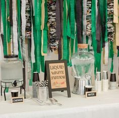 a table topped with lots of different types of paper streamers hanging from the ceiling