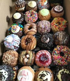 a box filled with lots of different flavored donuts