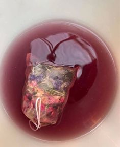 a bag filled with red liquid sitting on top of a white bowl