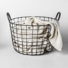 a black wire basket filled with white towels