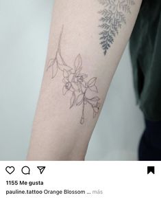 a tattoo on the arm of a woman with flowers and leaves tattooed on her arm