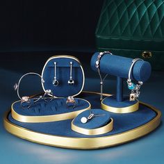 an assortment of jewelry is displayed on a blue surface with a green velvet bag in the background