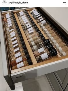 a drawer full of bottles and spices on top of a counter