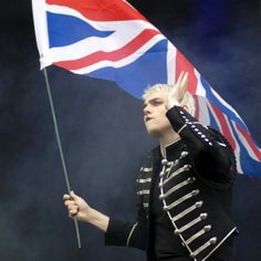 a man holding a british flag on top of a stage