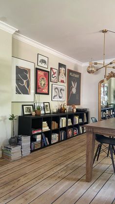 a dining room filled with lots of furniture and pictures on the wall next to a table