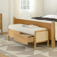 a bed with a wooden frame and foot board next to a window in a bedroom