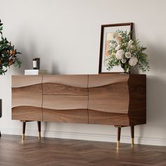 a large wooden cabinet sitting on top of a hard wood floor next to a potted plant