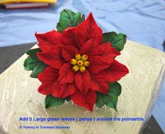 a red poinsettia flower sitting on top of a table