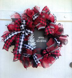 a red and black christmas wreath hanging on the side of a door